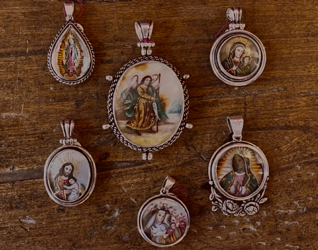 5 lockets or relicarios of various sizes - each with an image of a saint